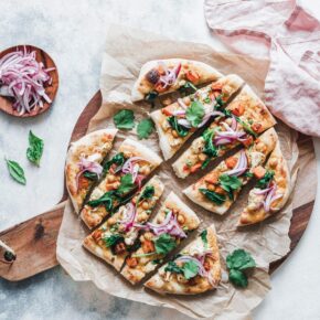 Naan-Pizza mit geröstetem Blumenkohl, Süßkartoffel und pinken Zwiebeln